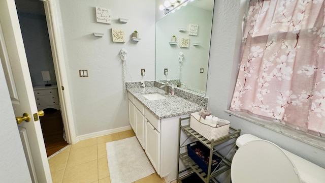 bathroom featuring vanity, baseboards, and tile patterned floors