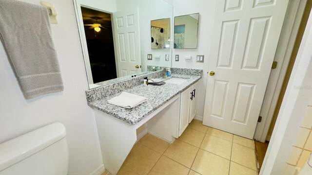 full bathroom with toilet, a ceiling fan, vanity, baseboards, and tile patterned floors