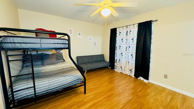 bedroom featuring ceiling fan, wood finished floors, and baseboards