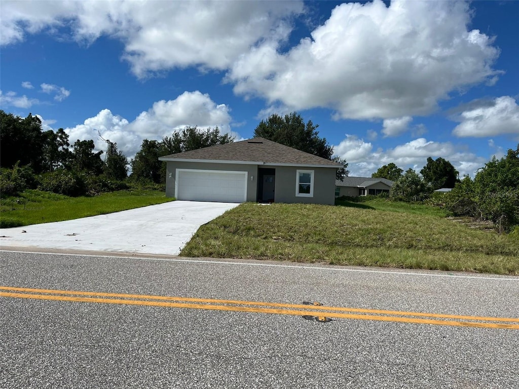 12577 Willmington Blvd, Port Charlotte, FL 33981 - view of front of house with a garage, driveway, stucco siding, and a front lawn