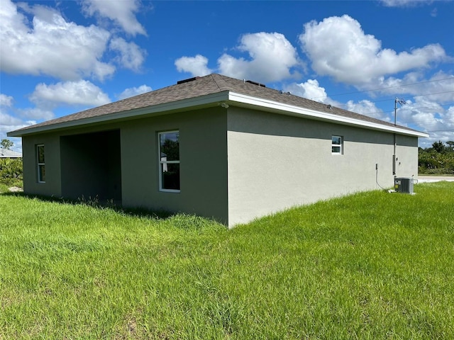 view of side of home featuring cooling unit and a lawn