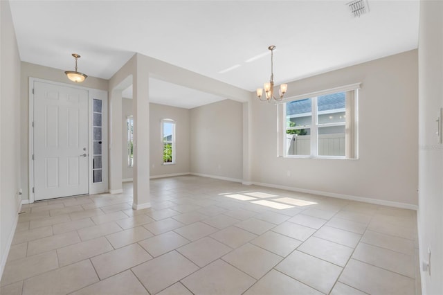 tiled foyer entrance featuring a chandelier