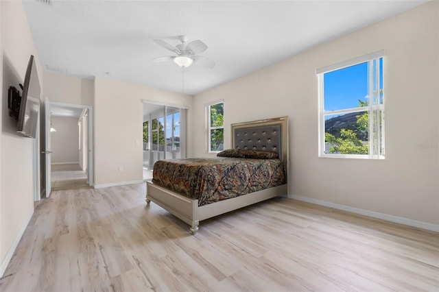 bedroom featuring multiple windows, ceiling fan, and light hardwood / wood-style floors