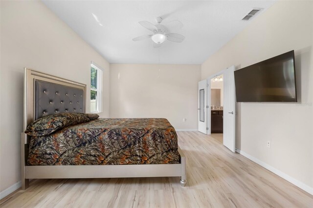 bedroom with ceiling fan, connected bathroom, and light hardwood / wood-style flooring