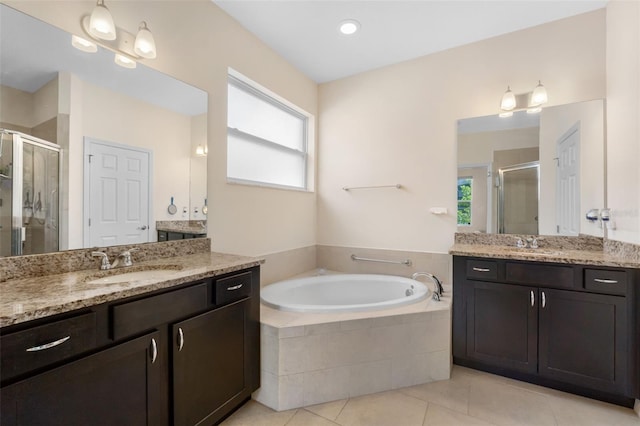 bathroom with tile patterned floors, shower with separate bathtub, and vanity