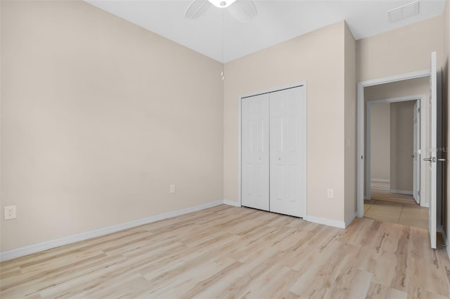 unfurnished bedroom with light wood-type flooring, a closet, and ceiling fan