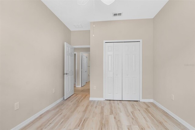 unfurnished bedroom with light hardwood / wood-style flooring and a closet