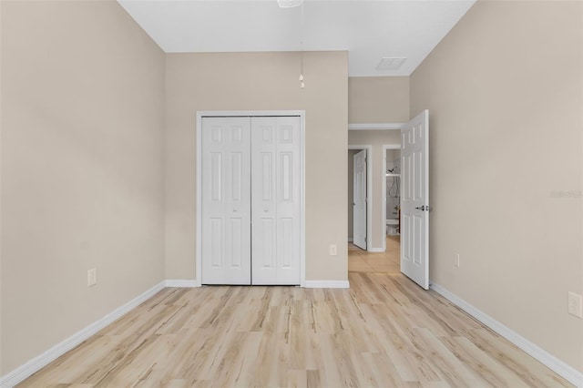 unfurnished bedroom with a closet and light hardwood / wood-style floors