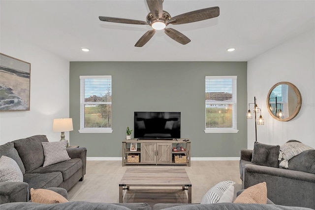 living room with ceiling fan, plenty of natural light, and light tile patterned floors