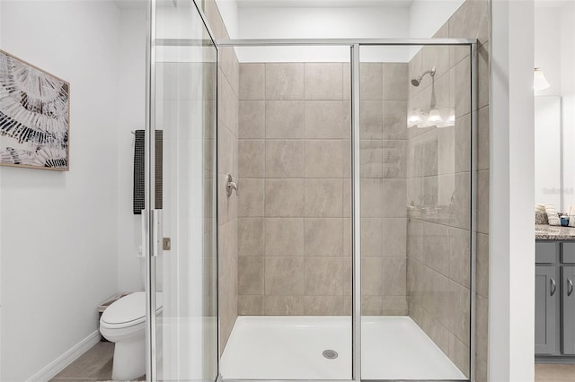 bathroom featuring an enclosed shower, vanity, and toilet