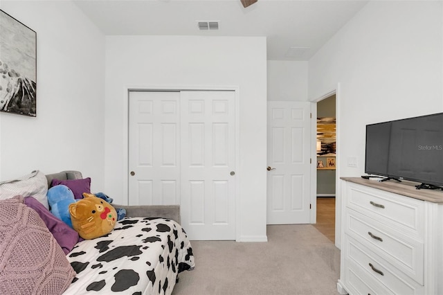 bedroom with light colored carpet and a closet