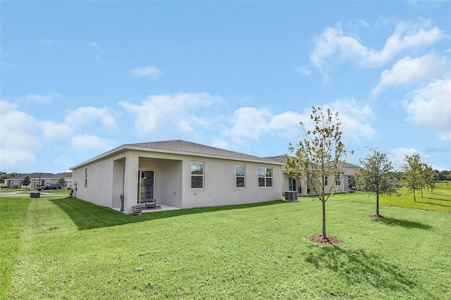 back of house featuring a patio, central air condition unit, and a lawn