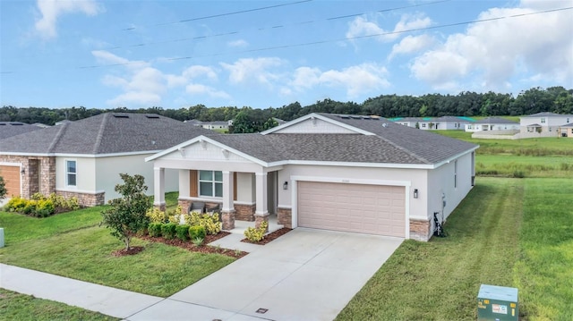 view of front of property with a garage, driveway, stone siding, a front yard, and stucco siding