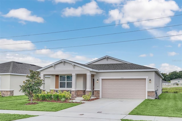 craftsman-style house with a garage, stone siding, a front yard, and driveway