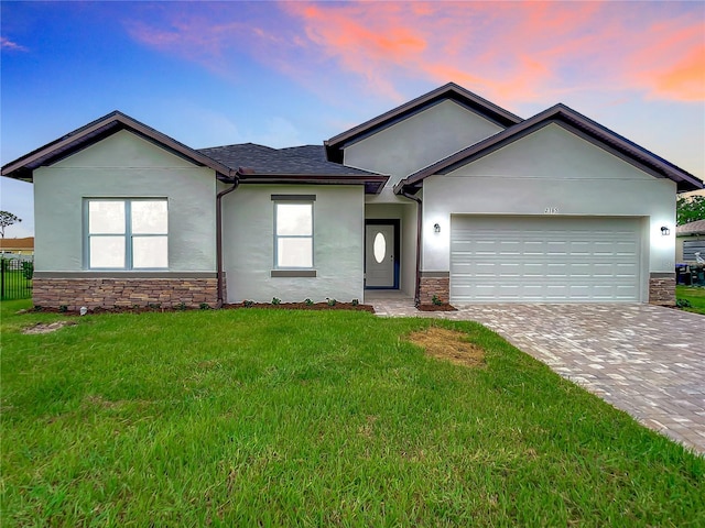 ranch-style home featuring a lawn and a garage