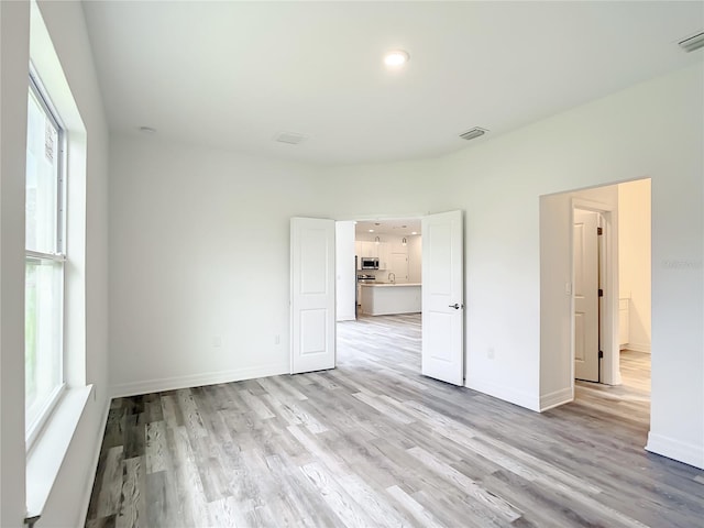 spare room with light hardwood / wood-style flooring