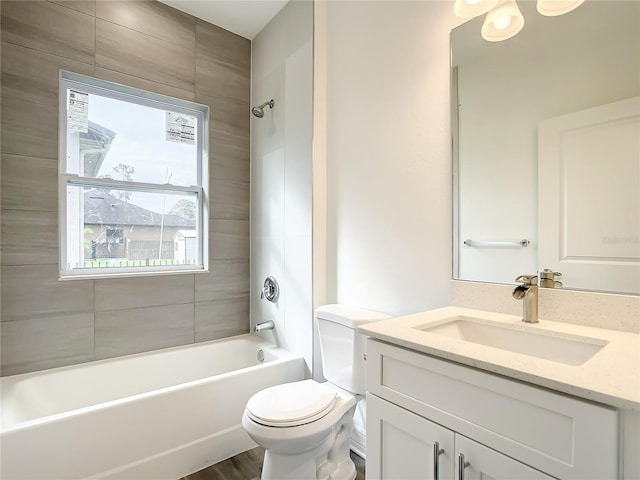 full bathroom with hardwood / wood-style flooring, vanity, toilet, and tiled shower / bath