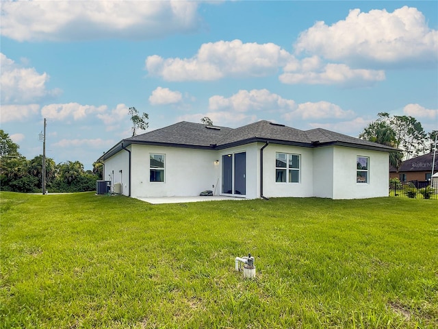 rear view of house featuring central air condition unit, a patio area, and a yard