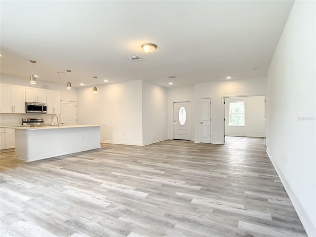 unfurnished living room featuring light hardwood / wood-style flooring and sink