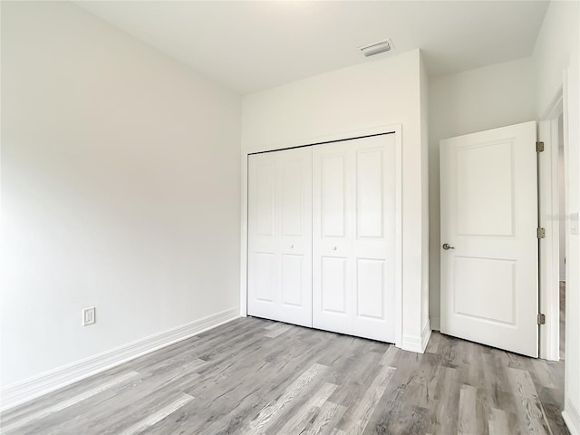 unfurnished bedroom with a closet and light hardwood / wood-style flooring