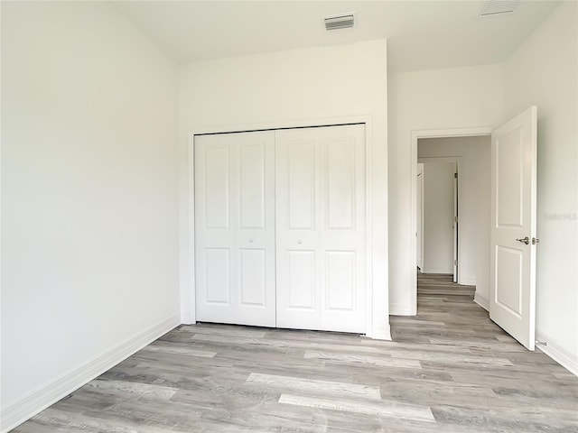 unfurnished bedroom with a closet and light hardwood / wood-style floors