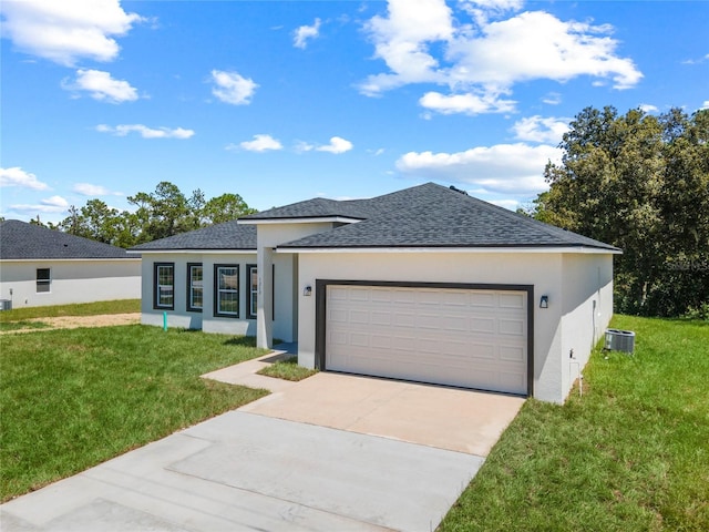 view of front of property with a garage, a front lawn, and central AC