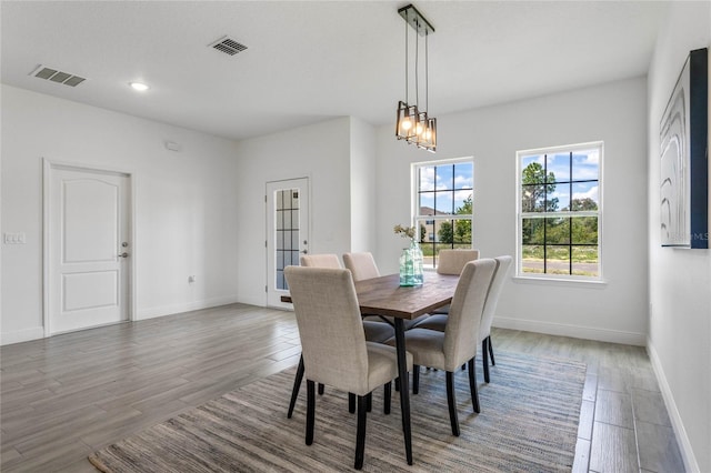 dining area with dark hardwood / wood-style floors and an inviting chandelier