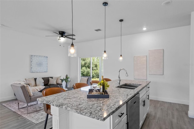 kitchen featuring dishwasher, an island with sink, sink, ceiling fan, and white cabinets