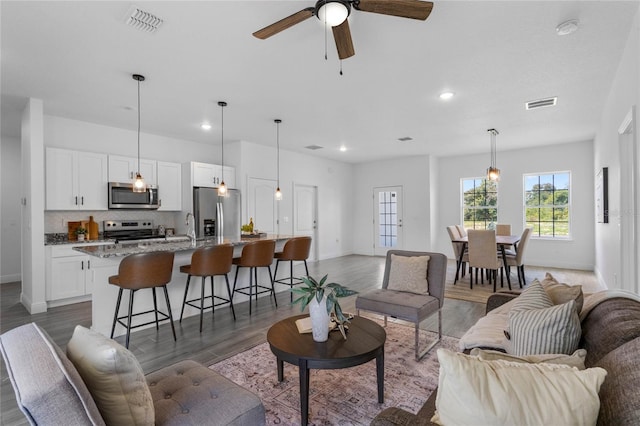 living room with ceiling fan, dark hardwood / wood-style flooring, and sink