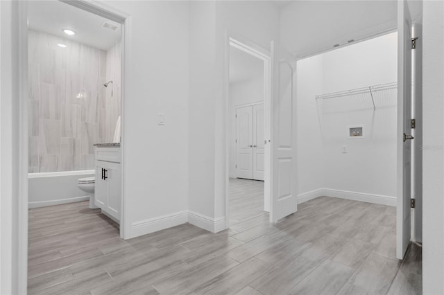 bathroom featuring tiled shower / bath, toilet, and hardwood / wood-style flooring