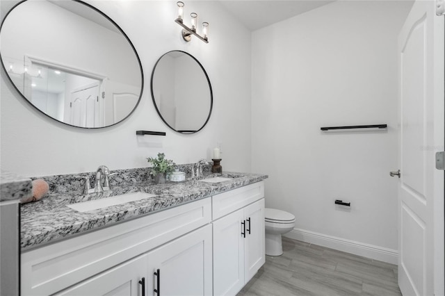 bathroom with wood-type flooring, toilet, and vanity