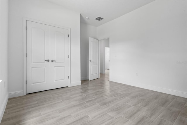 unfurnished bedroom featuring light wood-type flooring and a closet