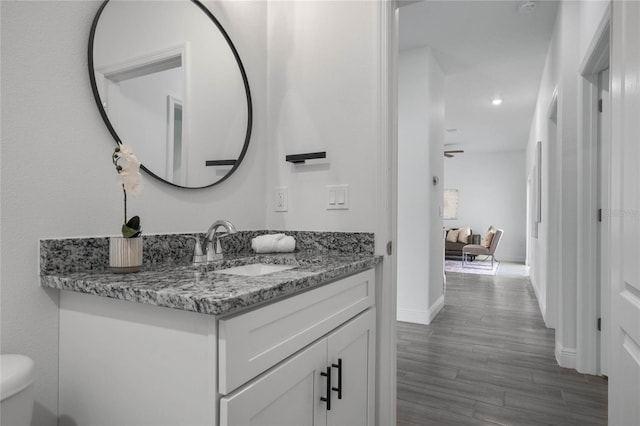 bathroom with vanity, toilet, and hardwood / wood-style flooring