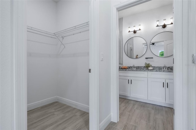 spacious closet with light wood-type flooring and sink