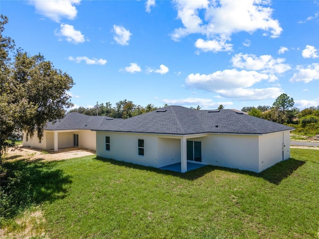 rear view of house featuring a yard and a patio