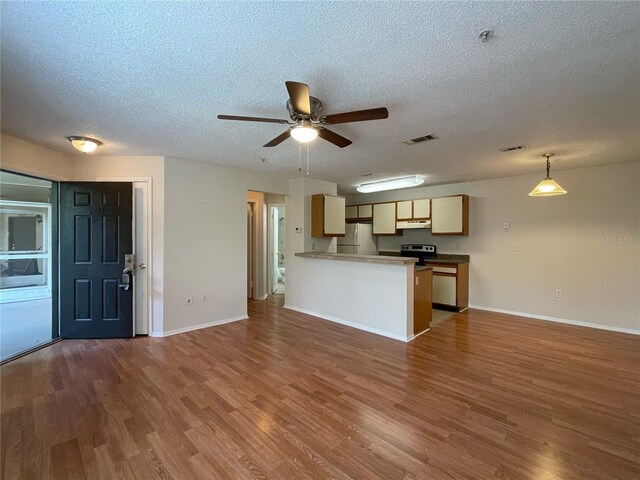 unfurnished living room with a textured ceiling, ceiling fan, and wood-type flooring