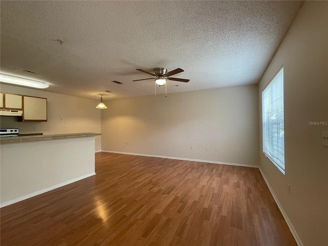 unfurnished living room with ceiling fan, hardwood / wood-style flooring, and a textured ceiling