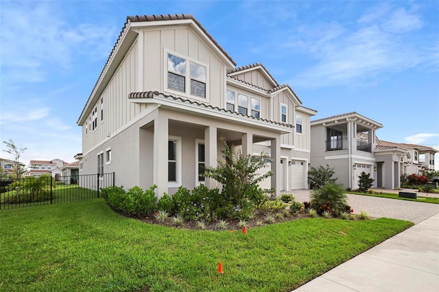 view of front of property with a balcony, a front yard, and a garage