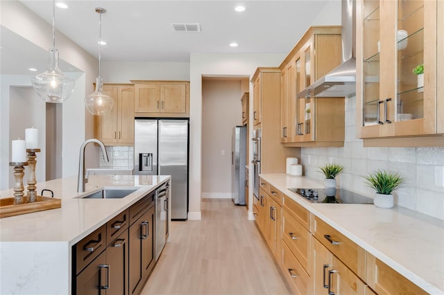 kitchen with decorative light fixtures, light hardwood / wood-style floors, sink, wall chimney range hood, and black electric stovetop