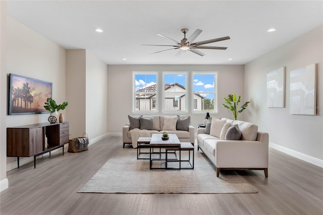 living room featuring ceiling fan and light hardwood / wood-style flooring