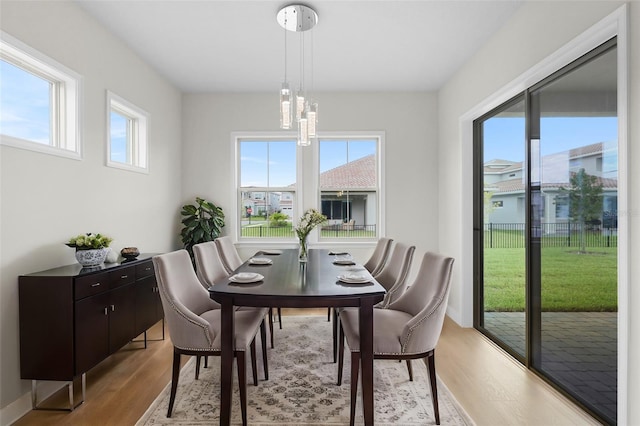 dining room with light hardwood / wood-style flooring and a notable chandelier