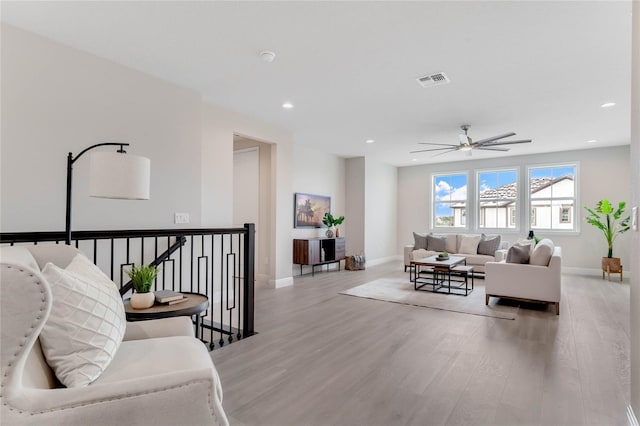 living room featuring light wood-type flooring and ceiling fan