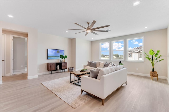 living room featuring ceiling fan and light hardwood / wood-style floors