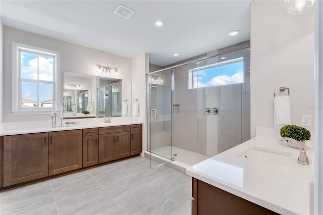 bathroom with a shower with shower door and vanity