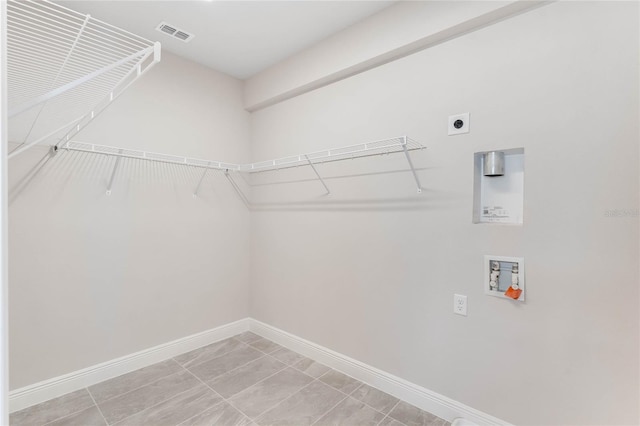 clothes washing area featuring hookup for a washing machine, light tile patterned floors, and electric dryer hookup