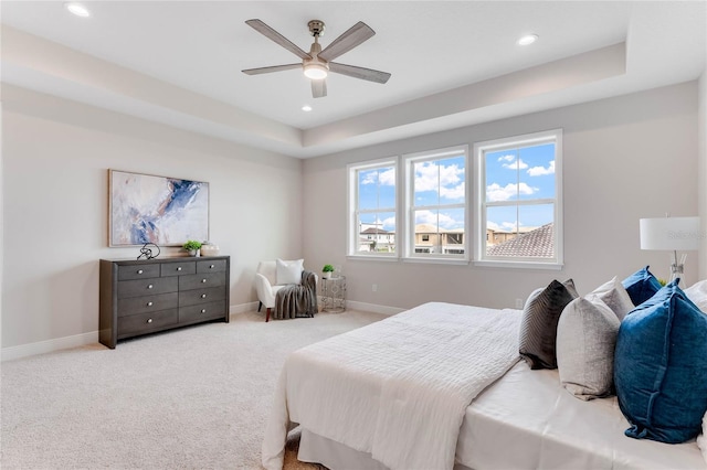 carpeted bedroom featuring a raised ceiling and ceiling fan