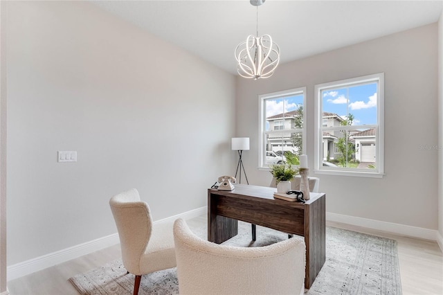 office with an inviting chandelier and light hardwood / wood-style floors