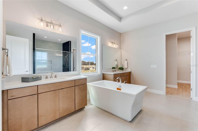 bathroom featuring tile patterned flooring, shower with separate bathtub, and vanity