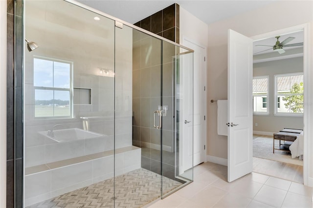 bathroom featuring a shower with shower door, ceiling fan, and tile patterned flooring