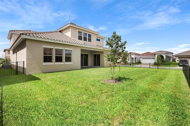 back of house with a lawn and a garage